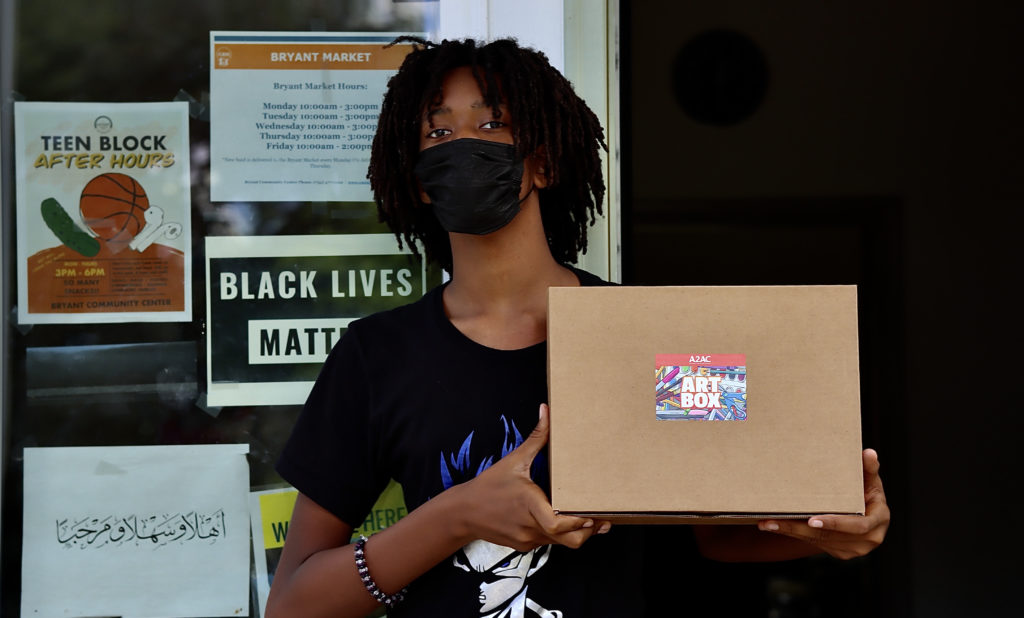 Young man holding art box