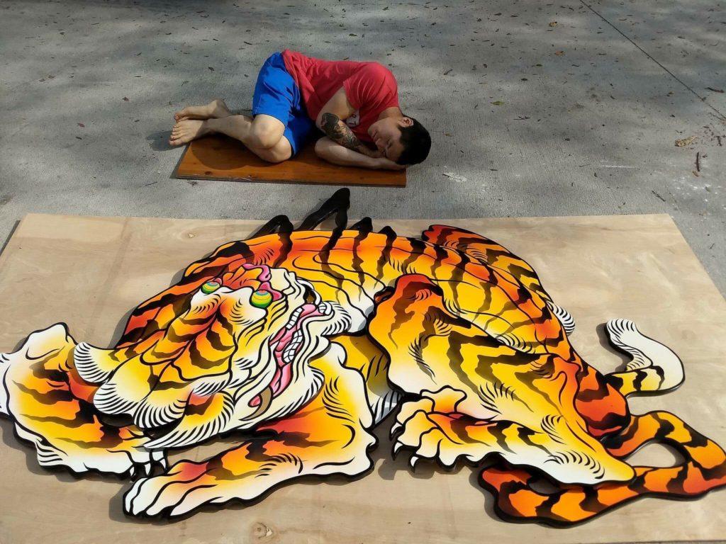 Photo of Boy Kong next to his artwork